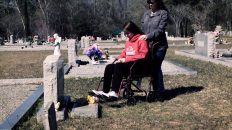 Girl in a wheelchair by a gravesite