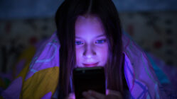 Girl looking at her phone at night