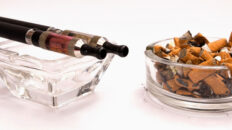 e-cigarettes next to a cigarette butts in an ashtray