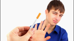 A teen waving off a cigarette
