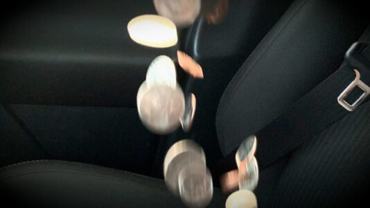 Loose coins spill to the seat of a crashing car