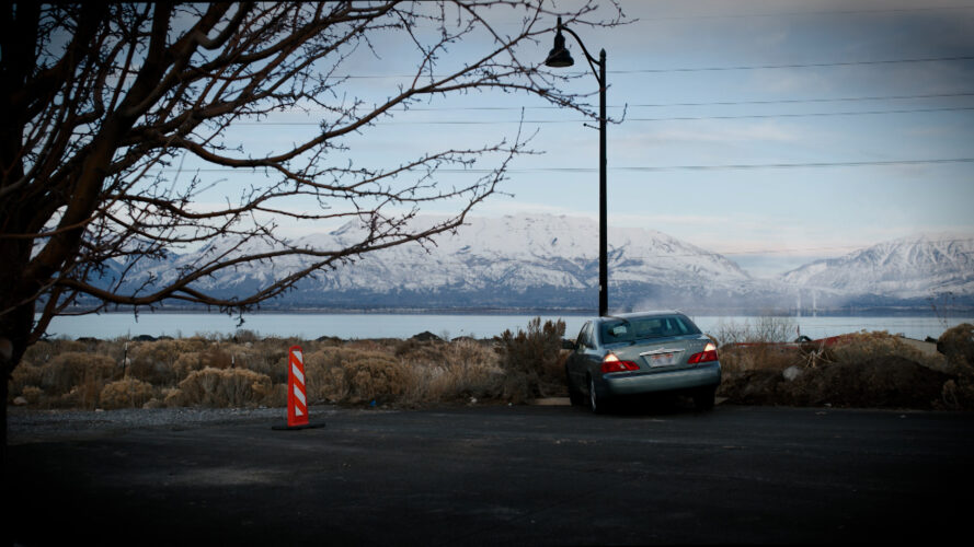 Smoke billows from a car crash on a lonely road