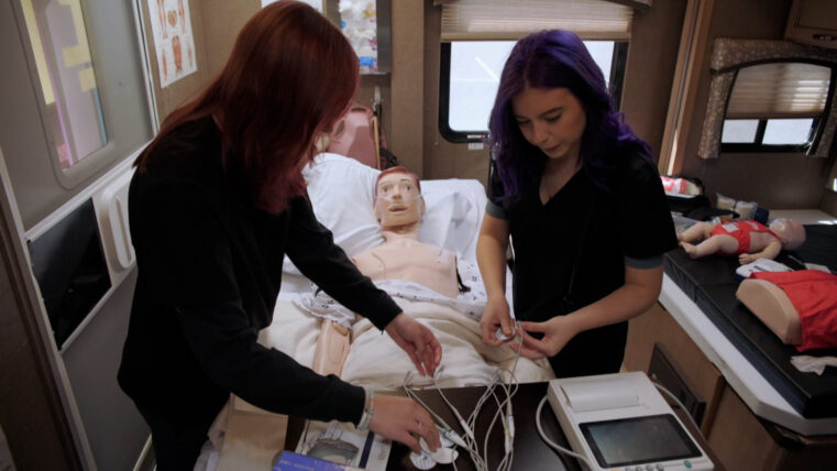 Two future nurses practicing on a dummy