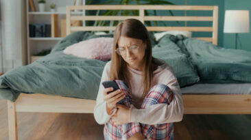 A girl looks at social media on her smart phone